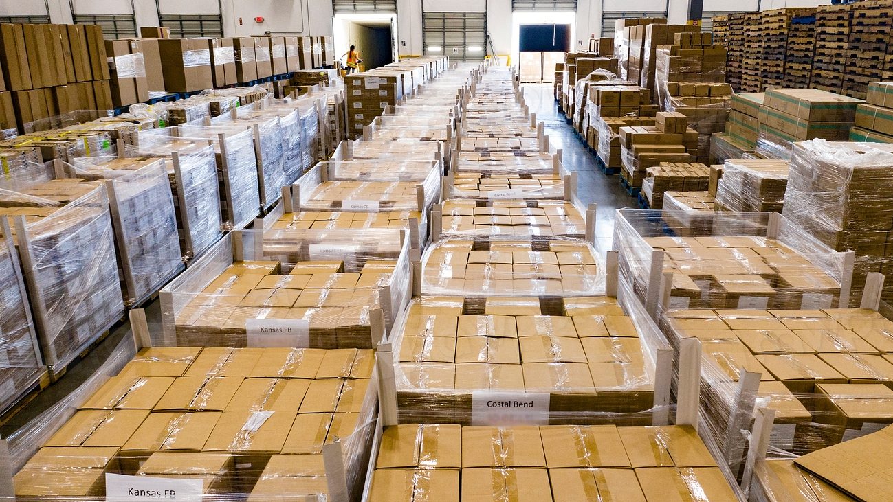 Long warehouse aisles stacked with palletised cartons