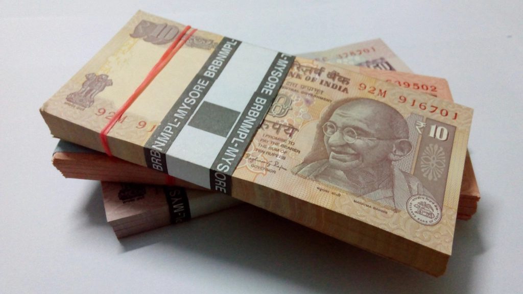 Bundles of Indian rupee notes stacked on a desk